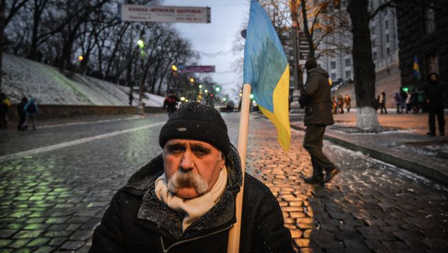 Мужчина с флагом Украины возле здания кабинета министров Украины в Киеве Мужчина с флагом Украины возле здания кабинета министров Украины в Киеве