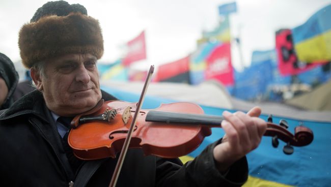 Мужчина играет на скрипке на митинге сторонников евроинтеграции Украины на площади Независимости в Киеве Мужчина играет на скрипке на митинге сторонников евроинтеграции Украины на площади Независимости в Киеве