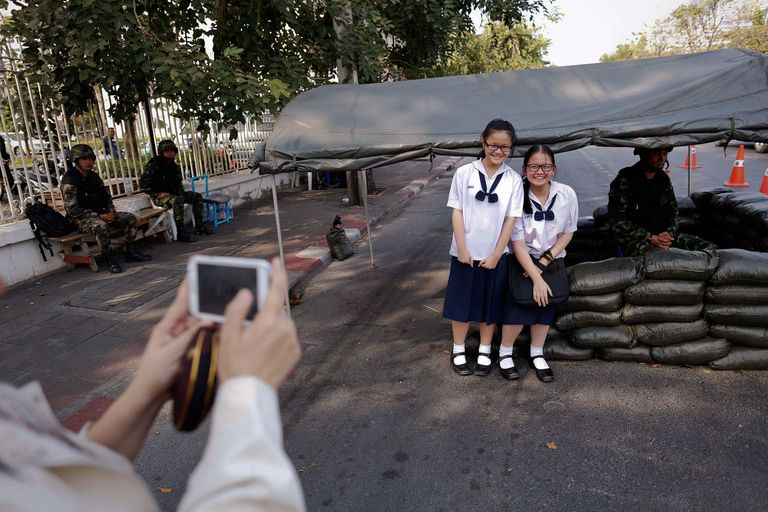 Студенты фотографируются у поста тайской армии недалеко от лагеря антиправительственных демонстраций в центре Бангкока 20 января 2014. Студенты фотографируются у поста тайской армии недалеко от лагеря антиправительственных демонстраций в центре Бангкока 20 января 2014.
