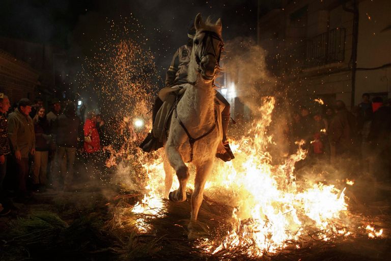 Человек едет на лошади сквозь пламя Человек едет на лошади сквозь пламя