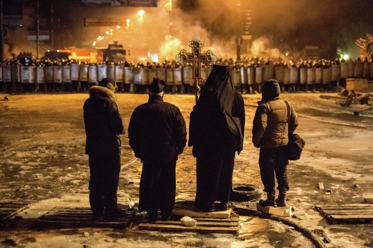 Священнослужители стоят между милицией и оппозицией на нейтральной территории, для предотвращения столкновений