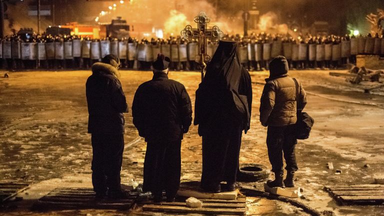 Священнослужители стоят между милицией и оппозицией на нейтральной территории, для предотвращения столкновений Священнослужители стоят между милицией и оппозицией на нейтральной территории, для предотвращения столкновений