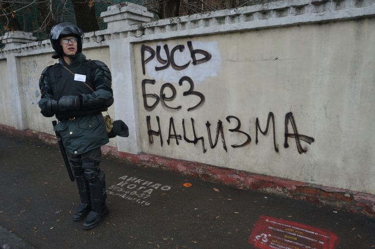 Сотрудник правоохранительных органов стоит в усилении во время проведения Русского марша в Москве. Сотрудник правоохранительных органов стоит в усилении во время проведения Русского марша в Москве.