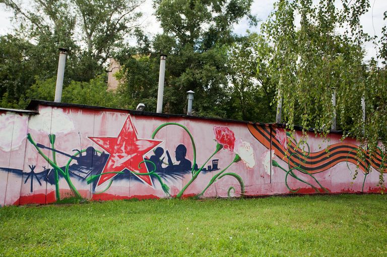 Граффити вдоль бетонного забора рядом с гаражами по улице Речников на юге Москвы Граффити вдоль бетонного забора рядом с гаражами по улице Речников на юге Москвы