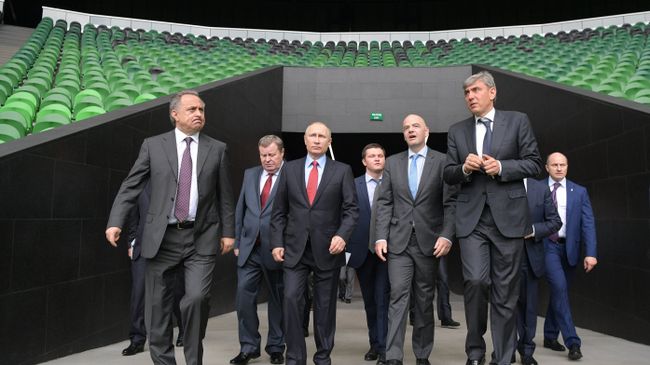 Владимир Путин во время посещения стадиона футбольного клуба Краснодар. Слева направо - Виталий Мутко и Владимир Устинов. Справа налево на первом плане - Сергей Галицкий и Джанни Инфантино Владимир Путин во время посещения стадиона футбольного клуба Краснодар. Слева направо - Виталий Мутко и Владимир Устинов. Справа налево на первом плане - Сергей Галицкий и Джанни Инфантино