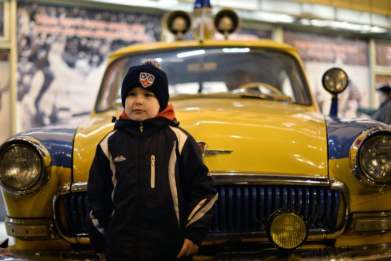 Юный болельщик позирует фотографируется у милицейского автомобиля ГАЗ-21 Волга Юный болельщик позирует фотографируется у милицейского автомобиля ГАЗ-21 Волга