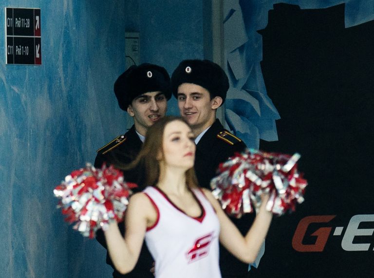Сотрудники полиции наблюдают за девушкой из группы поддержки Авангарда Сотрудники полиции наблюдают за девушкой из группы поддержки Авангарда